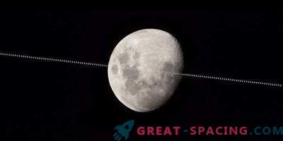 The International Space Station is flying against the background of the Moon